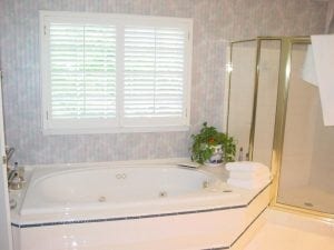 Before photo of bathroom with wallpaper on walls