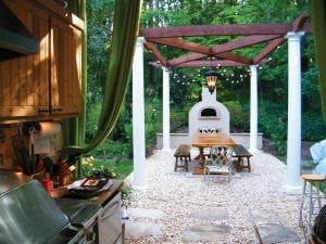 Beautiful backyard with annuals - the arbor with the fireplace is the focal point but there is also an outdoor kitchen for grilling food prep.