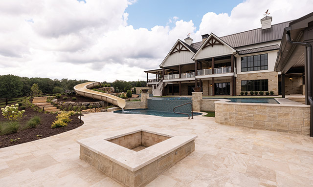 Backyard with a pool, water slide and a firepit