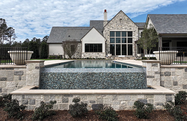 Luxury backyard featuring a custom Indiana limestone pool deck and bluestone porch flooring by Fieldstone Center, a 2026 Backyard Boss.