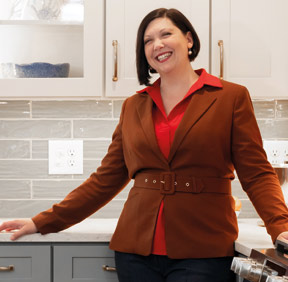 Miranda Esposito standing in front of the cabinets she designed